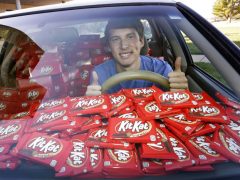 Een student in een auto vol terug met een stel KitKats op de achterbank.