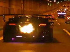 Een Lamborghini die door een tunnel rijdt waar vlammen uit komen.