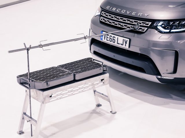 Een Land Rover Discovery geparkeerd naast een barbecue.