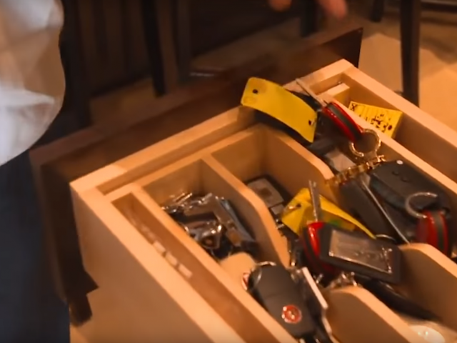 Een man houdt een la vol gereedschap uit de autocollectie van Floyd Mayweather vast.