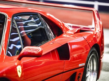Een rode Ferrari-sportwagen staat geparkeerd in een garage op de International Amsterdam Motor Show 2018.