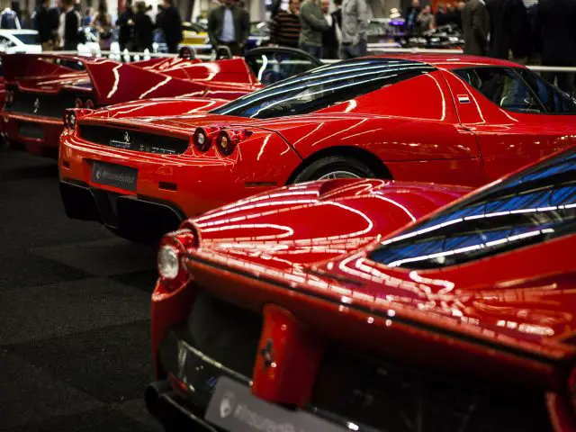 Een groep rode sportwagens geparkeerd op de International Amsterdam Motor Show 2018 op een parkeerplaats.