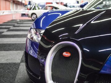 Een zwart-blauwe Bugatti Veyron geparkeerd in een garage, tentoongesteld op de International Amsterdam Motor Show 2018.