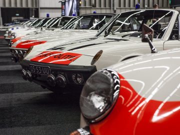 Een rij witte en rode auto's geparkeerd in een garage op de International Amsterdam Motor Show 2018.