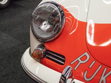 Een wit-oranje auto staat geparkeerd in een kamer op de International Amsterdam Motor Show 2018.