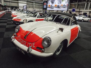 Een groep vintage Porsche-auto's geparkeerd in een kamer op de International Amsterdam Motor Show 2018.