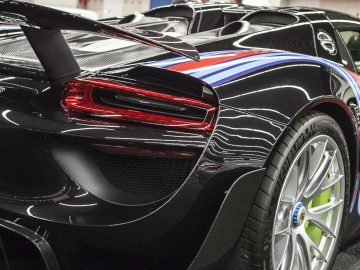 De achterkant van een zwart-blauwe sportwagen die werd tentoongesteld op de International Amsterdam Motor Show 2018.