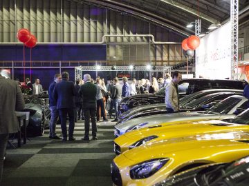 Een groep mensen staat rond een zaal vol gele sportwagens op de International Amsterdam Motor Show 2018.