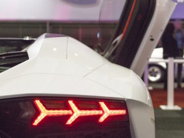 Een witte Lamborghini-sportwagen met een rood achterlicht, tentoongesteld op de International Amsterdam Motor Show 2018.