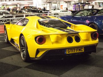 Een gele sportwagen staat geparkeerd in de showroom van de International Amsterdam Motor Show 2018.