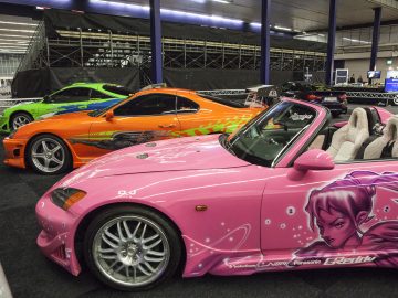 Een roze en oranje sportwagen staat geparkeerd op de International Amsterdam Motor Show 2018.
