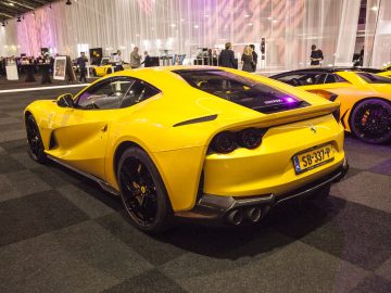Twee gele sportwagens geparkeerd in een kamer op de International Amsterdam Motor Show 2018.