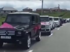 Een groep Mercedes-Benz GL-Klasse voertuigen staat opgesteld op de weg in een Tsjetsjeense trouwstoet.