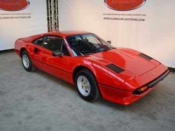 Een rode Ferrari-sportwagen staat geparkeerd in een galerij in Aaldering.