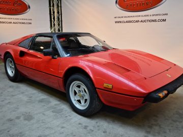 In de showroom van Gallery Aaldering staat een rode Ferrari-sportwagen geparkeerd.