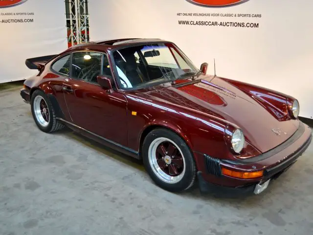 In de showroom van Gallery Aaldering staat een rode Porsche 911 geparkeerd.