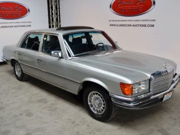 Een zilveren Mercedes Benz staat geparkeerd in een garage voor de megaveiling van Galerie Aaldering.