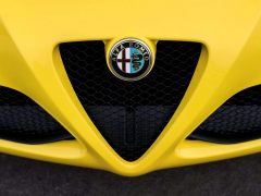 Een gele Alfa Romeo Formule 1-sportwagen met een logo op de grille.