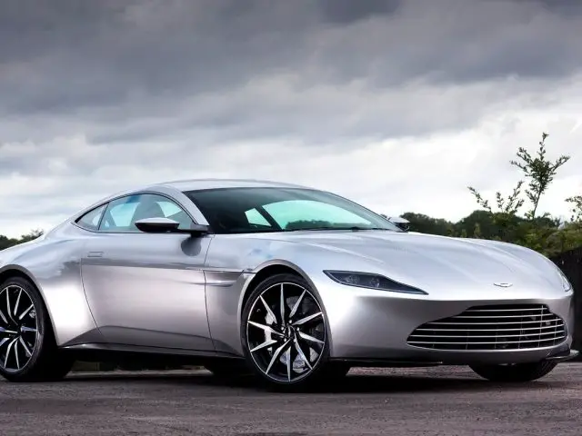 De zilveren Aston Martin Vantage-sportwagen staat geparkeerd op de weg.