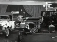 Een zwart-witfoto van antieke auto's in een showroom op de AutoRAI 1965, ter gelegenheid van het 50-jarig jubileum.