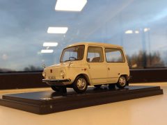 Een model van een kleine witte auto op een tafel voor een raam, tentoongesteld op de AutoRAI in Miniatuur.