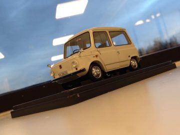 Een model van een kleine auto op een tafel voor een raam, representatief voor Zweden Nederland op AutoRAI in Miniatuur.