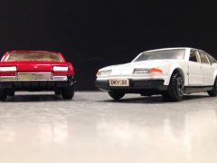 Een witte en rode Dinky Toys auto naast elkaar.