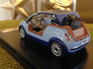 Een model van een kleine blauwe auto op standaard, te zien op de AutoRAI in Miniatuur.