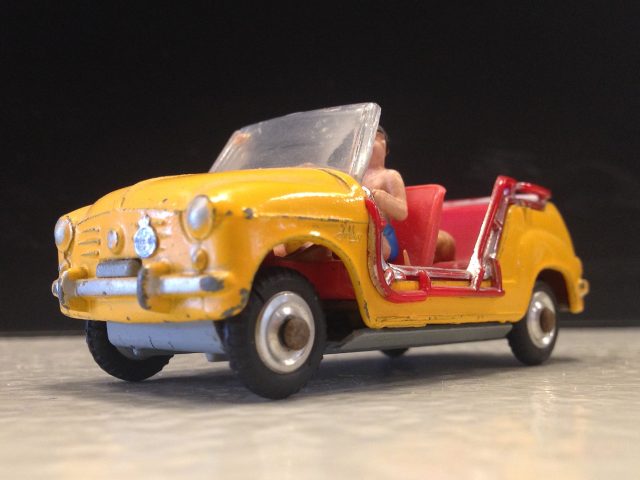 Een miniatuur speelgoedauto met een man erin.