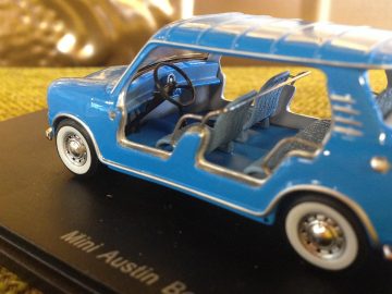 Een blauwe speelgoedauto op een tafel, geïnspireerd door AutoRAI in Miniatuur.