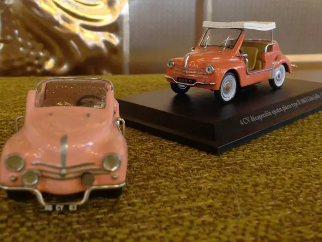 Een model van een roze auto en een model van een witte strandauto op de AutoRAI in Miniatuur.