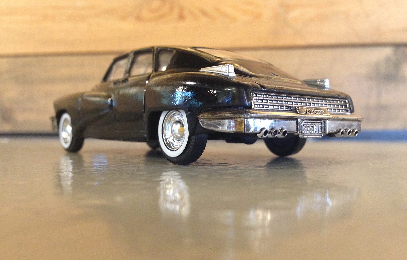 Een zwarte Tucker 48 speelgoedauto die op een tafel staat.