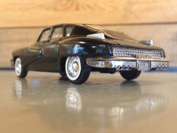 Een zwarte Tucker 48 speelgoedauto die op een tafel staat.