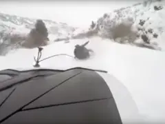 Een persoon die op een sneeuwscooter over een besneeuwde weg rijdt in een VIDEO.