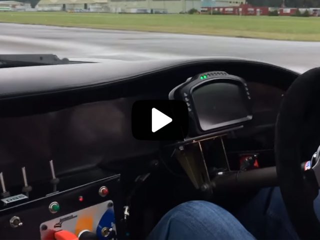 Een persoon die een raceauto met stuur bestuurt en fenomenale manoeuvres uitvoert op de baan.