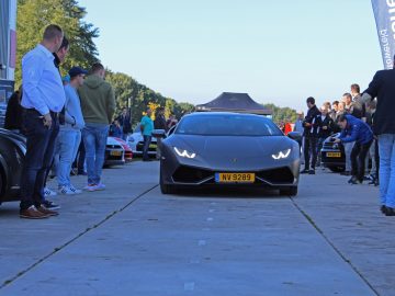 Een groep mensen staat voor een Lamborghini op de Borderrun Fly-in Car Show 2017.
