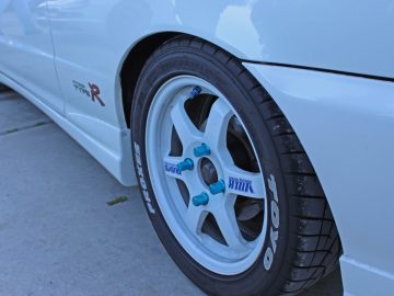Een close-up van een witte auto met blauwe velgen op de Car Show 2017.