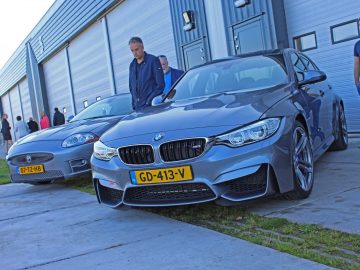 Twee mannen staan naast een BMW M4 uit 2017 en een Jaguar op de Borderrun Fly-in Car Show.