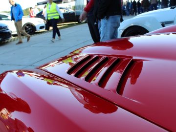 De motorkap van een rode sportwagen op de autoshow.