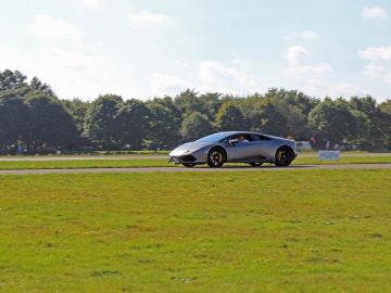 Een auto die over een grasveld rijdt tijdens de Borderrun Fly-in Car Show 2017.