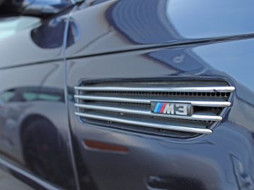 Een close-up van het BMW-embleem op een zwarte auto op de Borderrun Fly-in Car Show 2017.