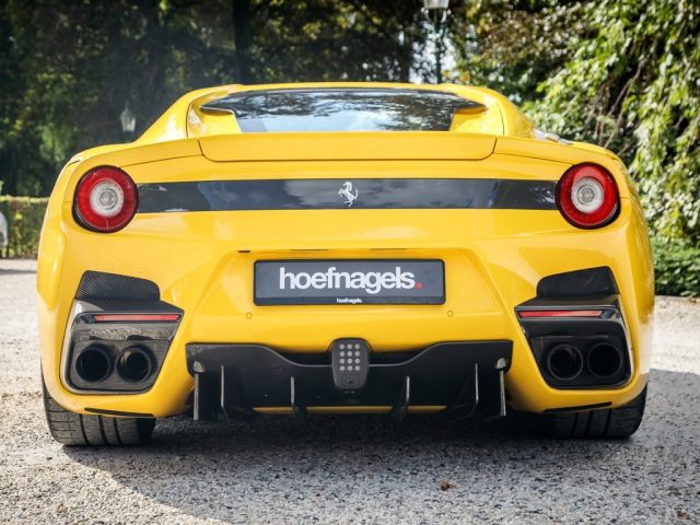 De achterkant van een gele Ferrari F12tdf-sportwagen.