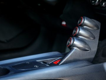 Ferrari F12tdf koolstofvezel shifter op een sportwagen.