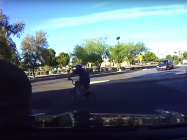 In een video fietst een man door de straat.