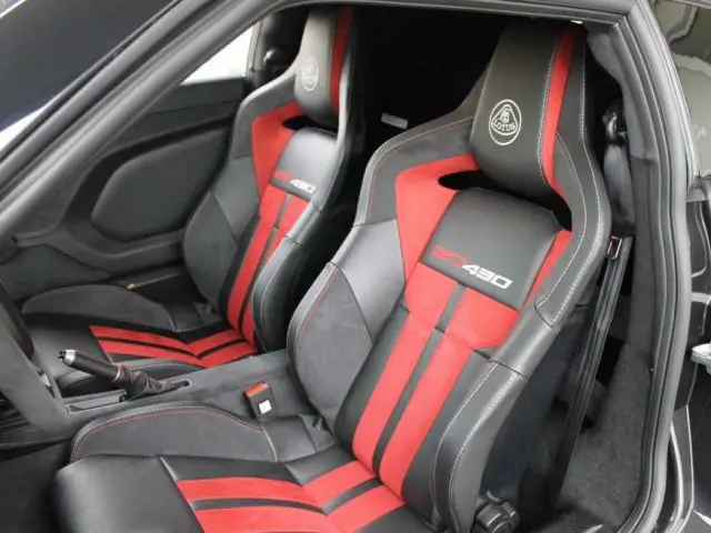 Het interieur van een Lotus Evora GT430 met chassisnummer 1 is voorzien van luxe zwarte en rode stoelen.