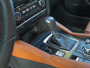 Het interieur van een Mazda 6 met een bruin lederen stuur.