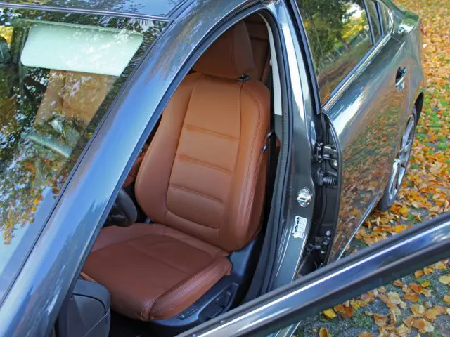 De open deur van een Mazda 6 met een bruin lederen stoel.