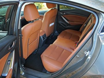 Het interieur van een Mazda 6 met bruin lederen stoelen.
