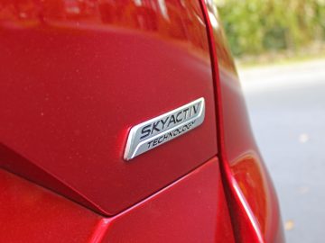 Een close-up van een rode badge op een Mazda CX-5.