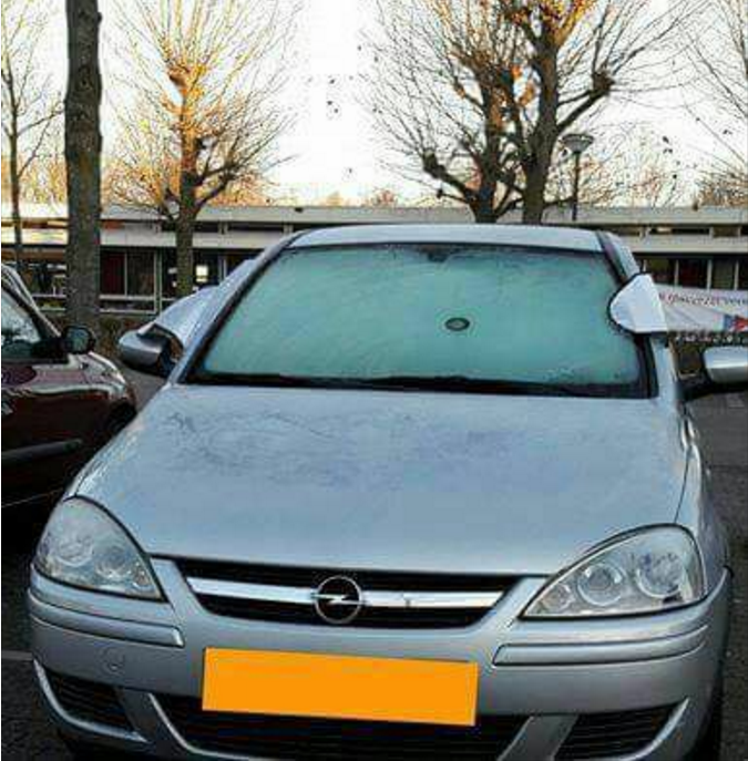 Een zilveren auto geparkeerd op een parkeerplaats in Oost-Brabant.